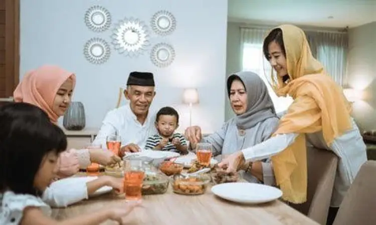 Keluarga muslim sedang berbuka puasa dengan hangat