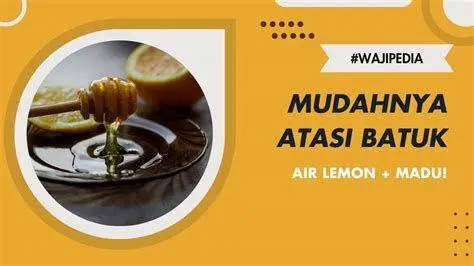 Madu sebagai Obat Batuk Madu dan irisan lemon dalam wadah kaca