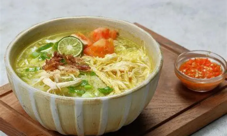 Penyajian Soto Ayam Satu porsi soto ayam dengan jeruk nipis dan sambal