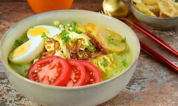 Semangkuk soto ayam kuning dengan topping lengkap