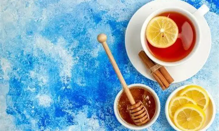 Ramuan Herbal Tenggorokan Ramuan madu dan lemon dalam gelas hangat