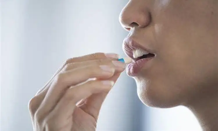 Seseorang mengonsumsi kapsul herbal untuk kesehatan