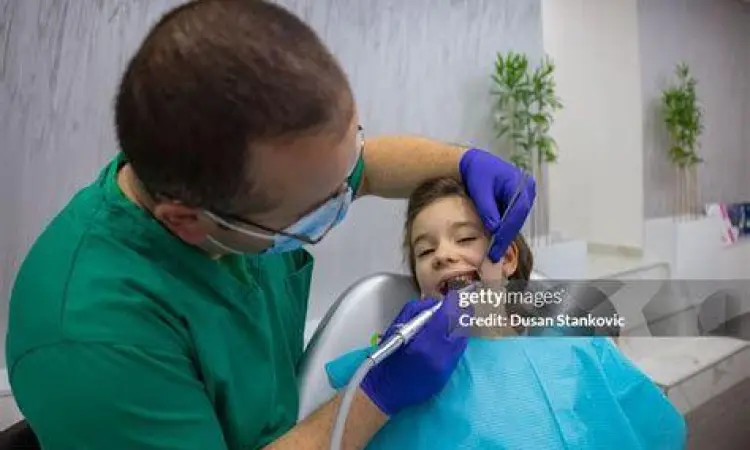 Dokter gigi melakukan prosedur pembersihan karies