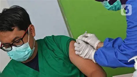 Pemberian Vaksin Profesional Tenaga medis profesional melakukan penyuntikan vaksin kepada pasien