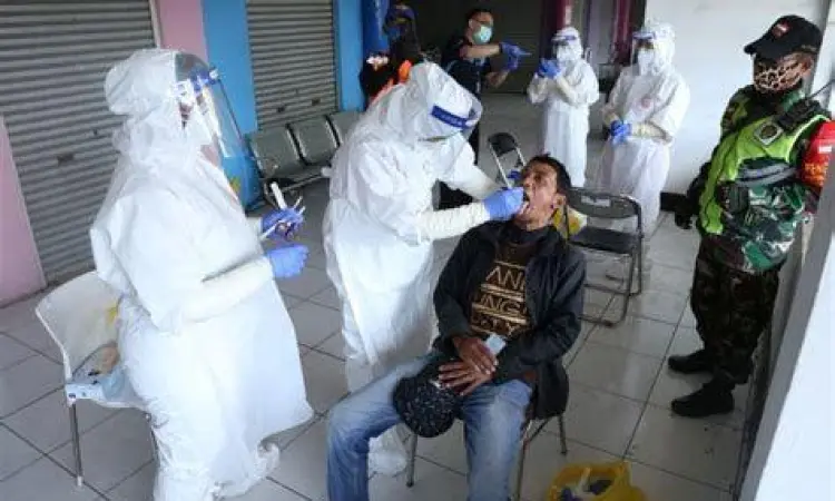 Pengambilan Sampel Medis petugas medis melakukan pengambilan sampel swab pada pasien