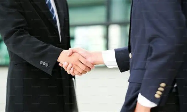 Dua orang bersalaman menandakan kesepakatan dari usaha keras