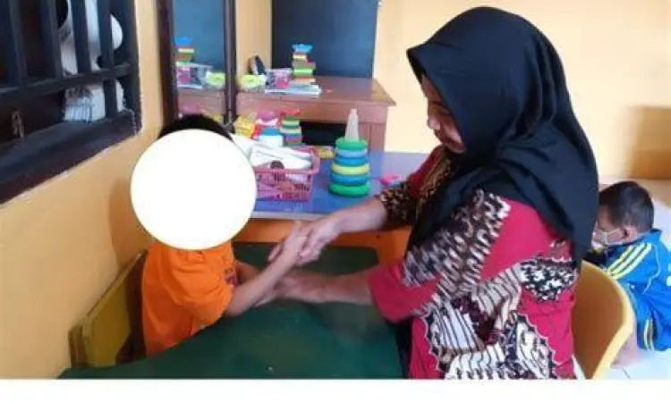Anak down syndrome mengikuti sesi terapi wicara dengan terapis